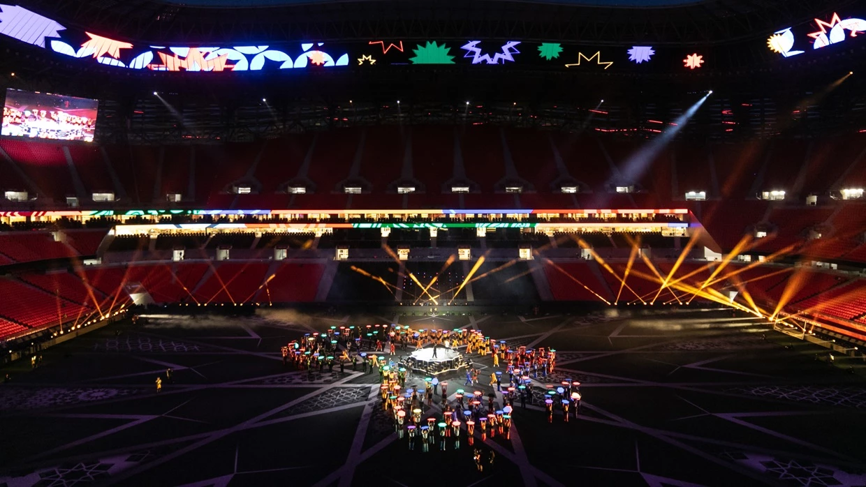 An overview image taking at the TotalEnergies CAF Africa Cup of Nations 2025 Opening Ceremony at Prince Moulay Abdellah Stadium in Rabat, Morocco. On the field multiple dancers are holding Hex Panels a technical solution designed and engineered by PRG Projects. The dancers stand together to create an simplified outline of the continent of Africa. The screens are displaying different colors.