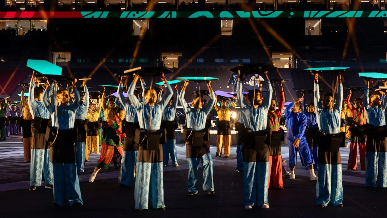 A close up of multiple dancers holding Hex Panels gen 2 at the TotalEnergies CAF Africa Cup of Nations 2025 Opening Ceremony. The hex panels were a technical solution created by PRG Projects. The Portable Hexagonally shaped LED screens are displaying different colors. The dancers are wearing battery belts to supply the LED with 3h of video.